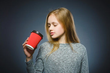 teenage girl drink red cup of coffee isolated on gray background