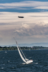 Sailing yacht race with zeppelin on the sky © Eva M