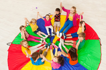 Kids holding hands together with teacher in gym - obrazy, fototapety, plakaty