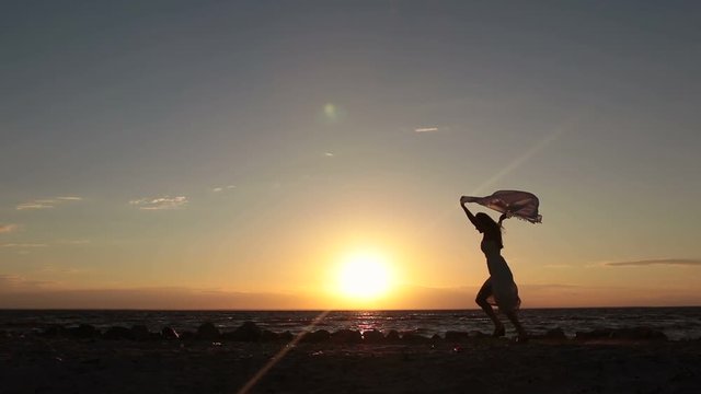 Woman Running With Flying Scarf On Beach At Sunset