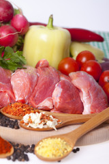  Raw meat, cut into pieces with pepper, cherry, radish, pepper and various spices in wooden spoons