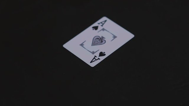 Ace pocker card falling on the black table