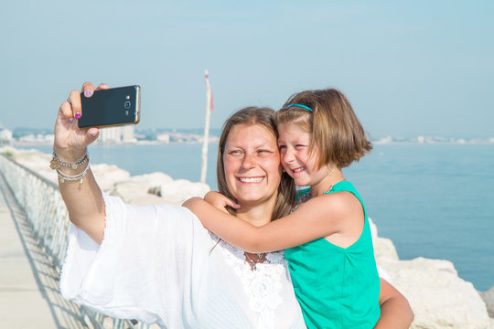Mom and daughter are taking a picture smiling