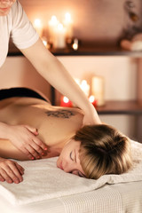 Obraz na płótnie Canvas Body massage and spa treatment in modern salon with candles