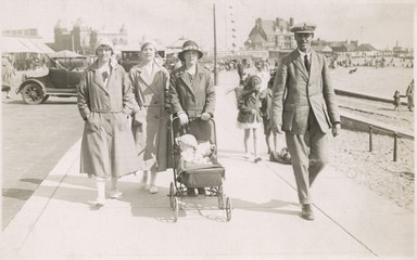 Family strolling along sea front with baby  1930s. Date: 1930s