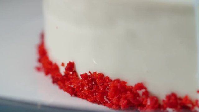 White cake with white cream, biscuit close up. Wedding cake with white lilac on a white table, close up, selective focus. Caramel party cake on a dark blue background