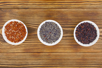 Raw blue rice in bowl on  wooden background