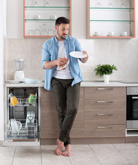Man unloading dishwasher