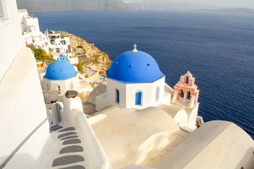 View of three blue domed churches and sea in Oia, Santorini, Greece