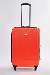 Red suitcase with metal handle. Large closed case, white background.