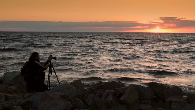 Man photographing beautiful sunset at seaside