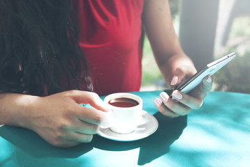 woman hand phone with cup of coffee