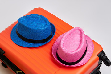 Colorful hats on modern suitcase. Close up of luggage with summer hats. Time for travelling.