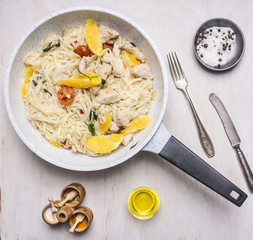 noodles with turkey, tomato and apesinami on a granite pan with herbs and cutlery top view