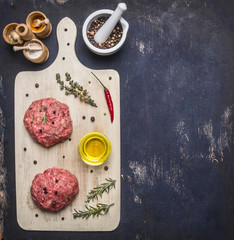 ingredients for cooking burgers, ground beef, tomatoes, red pepper and other spices laid out on a white cutting board with space for text Border