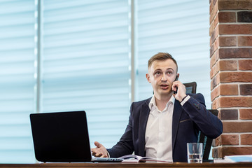 A businessman talking on a mobile phone,Businessman talking on the phone in office,Senior businessman,Portrait of businessman talking on mobile phone,business concept