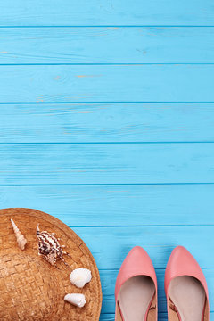 Summer vacation background, blue surface. Female sandals, straw hat, sea shells, retro sea space.