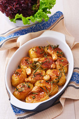 Roasted potatoes with garlic, thyme and rosemary in ceramic baking dish
