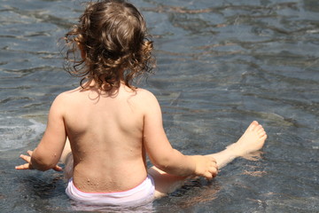 Italy, Milan, water games in a fountain of a little girl