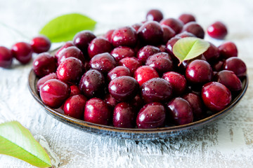 Fresh cherry on plate on wooden blue background. fresh ripe cherries. sweet cherries