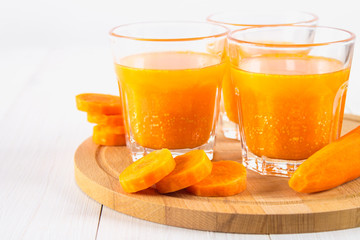 Fresh carrot juice on a wooden background