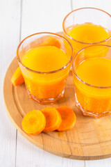 Fresh carrot juice on a wooden background
