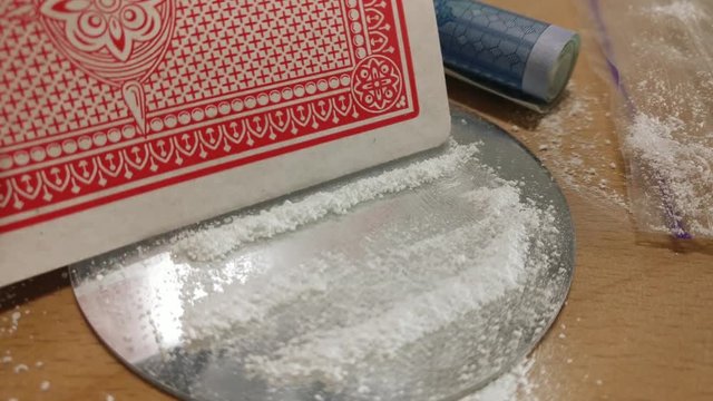 Man preparing cocaine lines with poker card on mirror close up.  Footage will work great for any videos dealing with opiate addiction, Life Danger, crime.