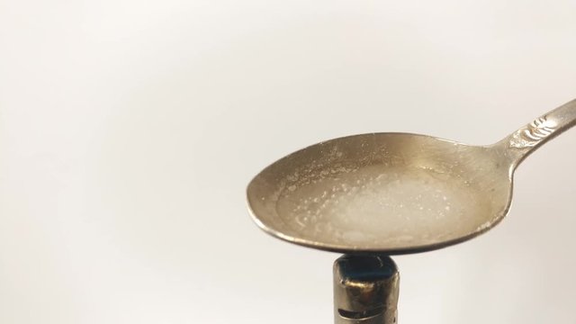 Man Preparing Dose Of cocaine by heating it with lighter in spoon.  Close up. Footage will work great for any videos dealing with opiate addiction, Life Danger, crime.