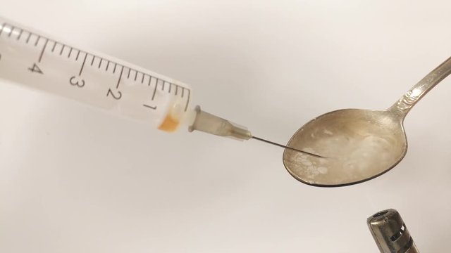 Liquid Drug Dose Boiling In Spoon.  Addict Fill A Syringe Dose Of cocaine From A Spoon.  Close up. Footage will work great for any videos dealing with opiate addiction, Life Danger, crime.