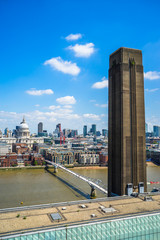 Fototapeta premium The old chimney of the Tate Modern Gallery on the right. St.Paul's Cathedral in the distance on the left and the Millennium walkway bridge. London UK. 