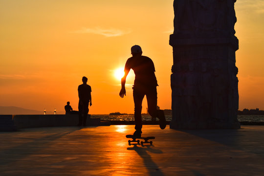 A boy skateboarding at sunset, silhouette. 