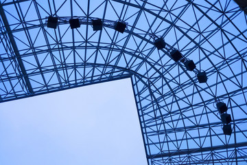 Fototapeta premium Stadium roof construction against blue sky. Modern architecture elements