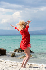 Outdoor portrait of young beautiful blonde woman jumping on the beach, fit sporty healthy body in bikini, woman enjoys wind, freedom, vacation, summertime fun concept. © Cristina Jurca