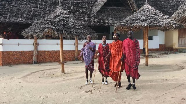 The Masai tribe dances their national African dance on the Indian Ocean beach at sunset and bids farewell to the sun. Tanzania. Zanzibar. Slow motion. 4K.