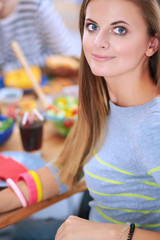 Top view of group of people having dinner together while sitting at wooden table. Food on the table. People eat fast food. Portrait of a girl