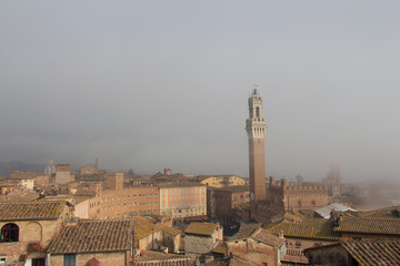 Fototapeta na wymiar Torre del Mangia in Piazza del Campo in mist. Tuscany, Italy.