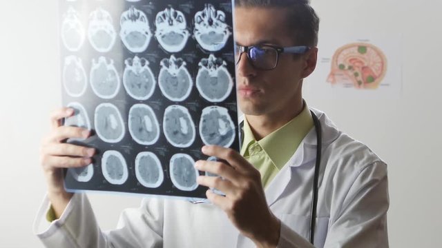 A neurosurgeon doctor looks at a Magnetic resonance imaging MRI snapshot of the brain