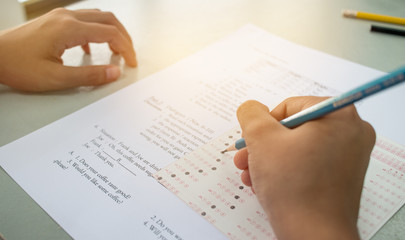 Asian student testing english exam or exercise on exams answer sheets with pencil in class room at school, education concept