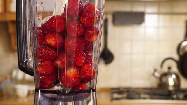 Making fresh banana strawberry fruit shake milkshake at home in blender high speed machine. Healthy eating, vegetarian food, diet concept. 4K ProRes HQ codec
