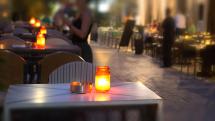 A jar with a candle on a table at night.