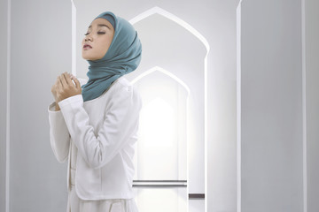 Fototapeta na wymiar Pretty asian muslim woman wearing raising hand and praying
