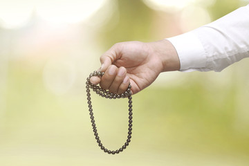 Muslim man praying with prayer beads