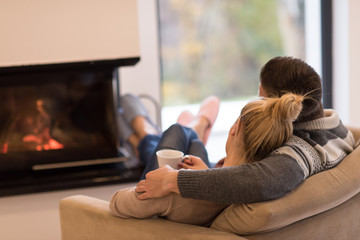 Young couple  in front of fireplace - Powered by Adobe