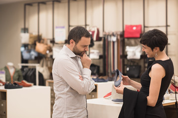 couple chooses shoes At Shoe Store