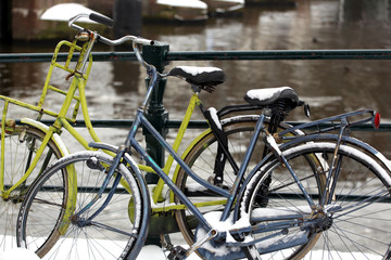 Fototapeta na wymiar Bikes parked in winter snow in Amsterdam, Netherlands.