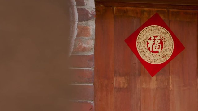 Taipei, Taiwan-12 February, 2016: An door of an old store in Bopiliao, a historical street in Taipei's old Wanhua District, Taiwan. The door has a red good luck poster.