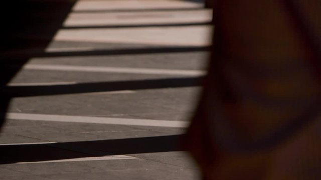 People are walking on a hallway in Bopiliao, a historical street in Taipei's old Wanhua District, Taiwan. There are shadows of the columns.
