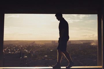 Lone roofer on roof at sunset