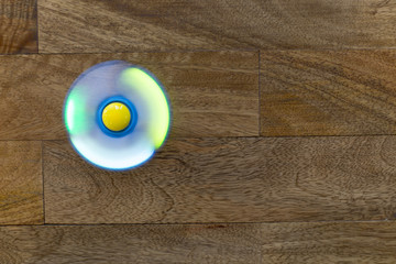 Play Fidget spinner spinning on wood background With Light