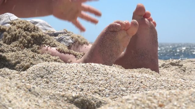 Childs bare feet in sand on beach